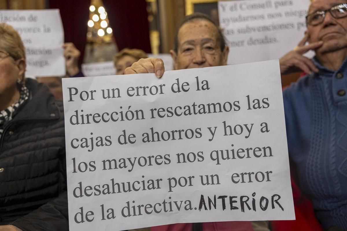 Un jubilado de Son Cladera con una pancarta en el pleno de esta mañana.