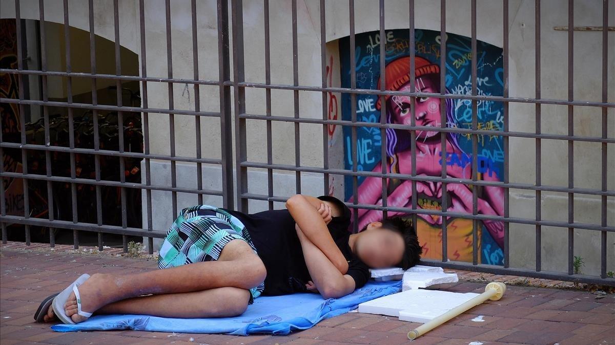 Un menor duerme en un parque de Barcelona, el viernes 5 de junio por la mañana. Un menor duerme en un parque de Barcelona, el viernes 5 de junio por la mañana.