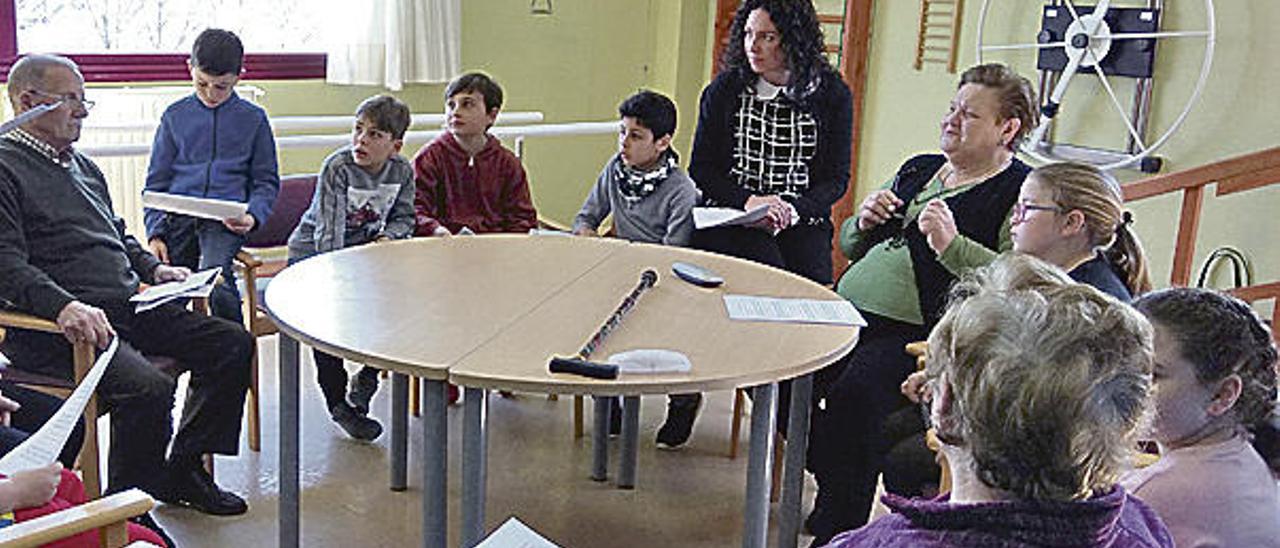 Mayores y pequeños en un ensayo de la lectura intergeneracional.