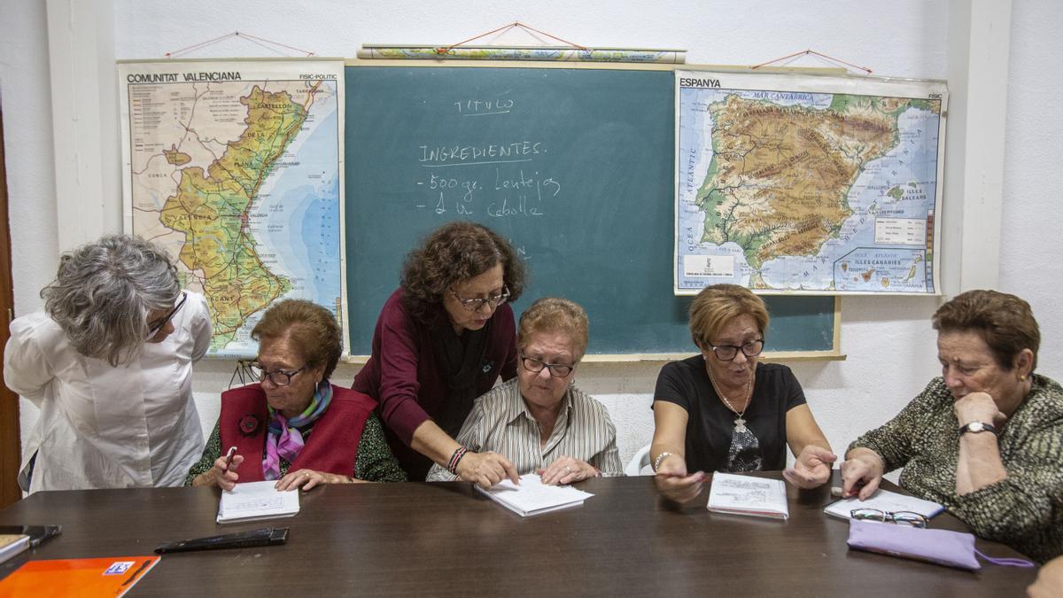 Ocho mujeres aprenden en un taller impartido por profesoras voluntarias.