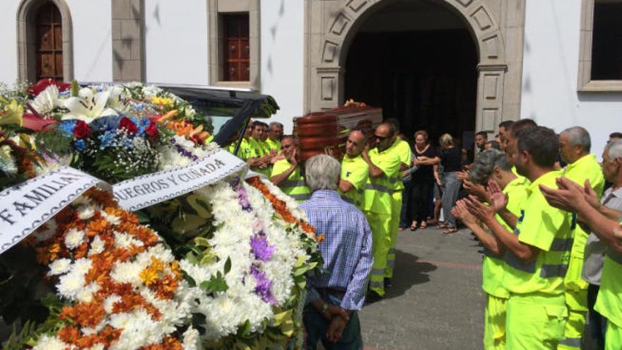 La salida de la iglesia de La Aldea, ayer, del féretro del operario Juan Román Padrón, llevado a hombros por compañeros del Servicio de Carreteras.