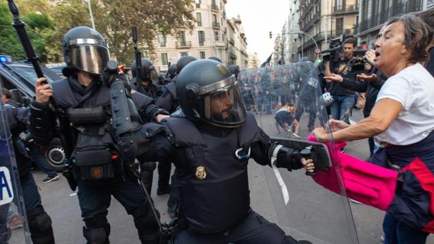 Un policia colpeja una senyora gran, a Barcelona.