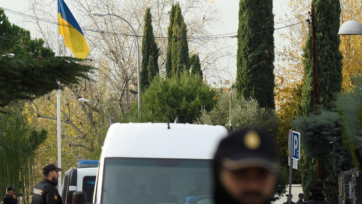 Policías españoles junto a una bandera ucraniana en la embajada de Ucrania en Madrid.