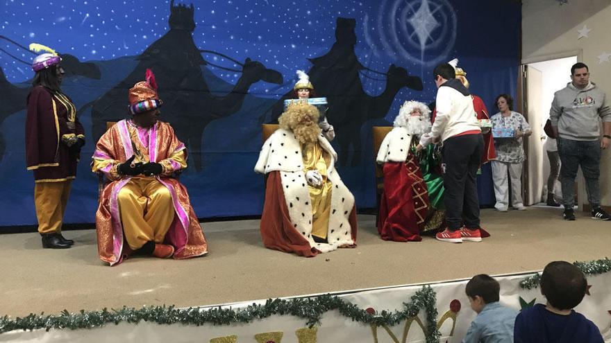 Una niña recibe su regalo de manos de Melchor.