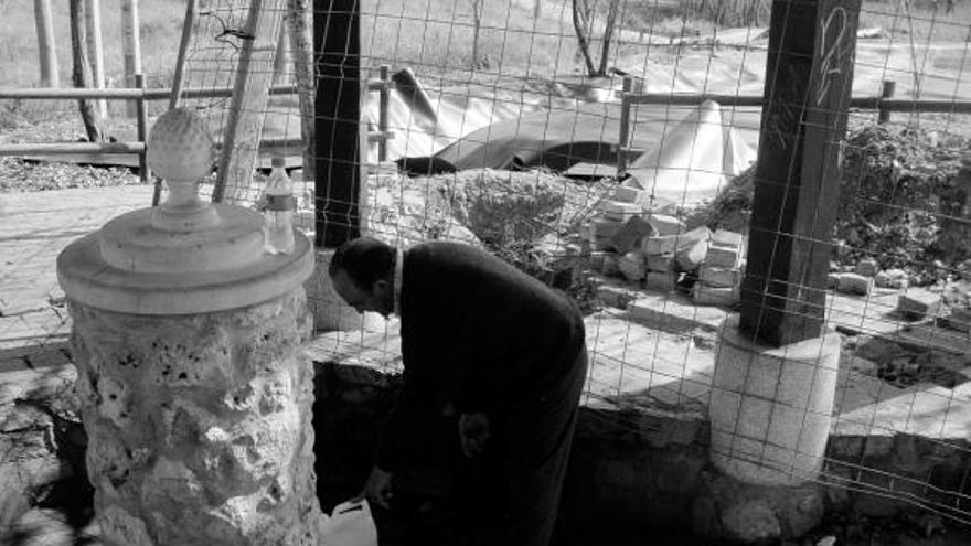 Un vecino llena una garrafa de agua en la fuente de Santa Marta de Tera. Al fondo, las obras de la balsa del área de recreo.