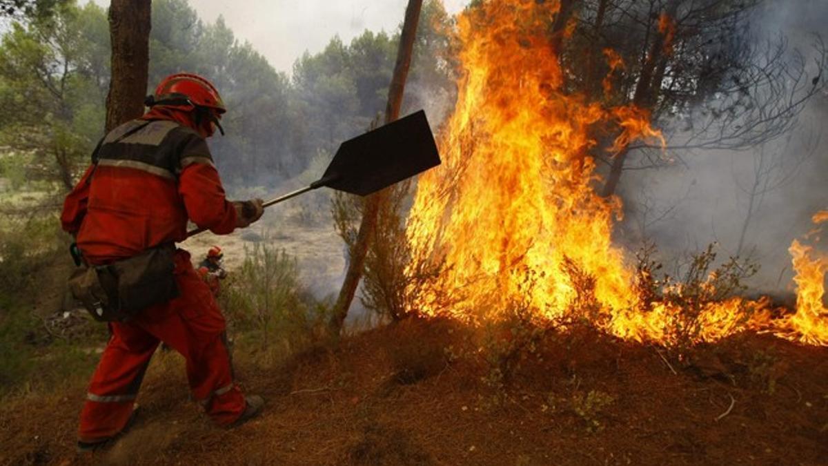 Un bombero intenta controlar el fuego, el domingo, en Alicante.