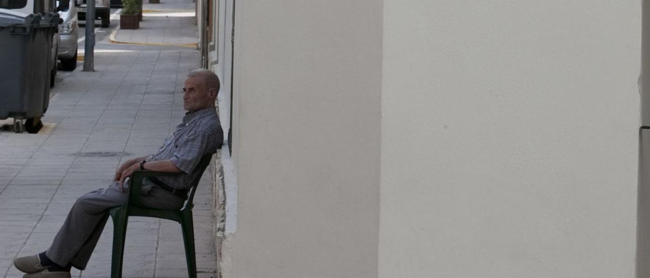 Un vecino de Quesa descansa en una silla ante la puerta de su casa, en una imagen de archivo. | PERALES IBORRA