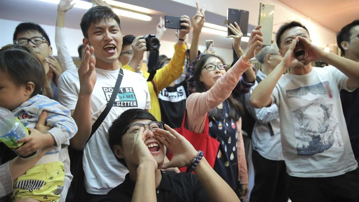 Jóvenes antigubernamentales celebran el resultado de las elecciones en Hong Kong, este domingo.