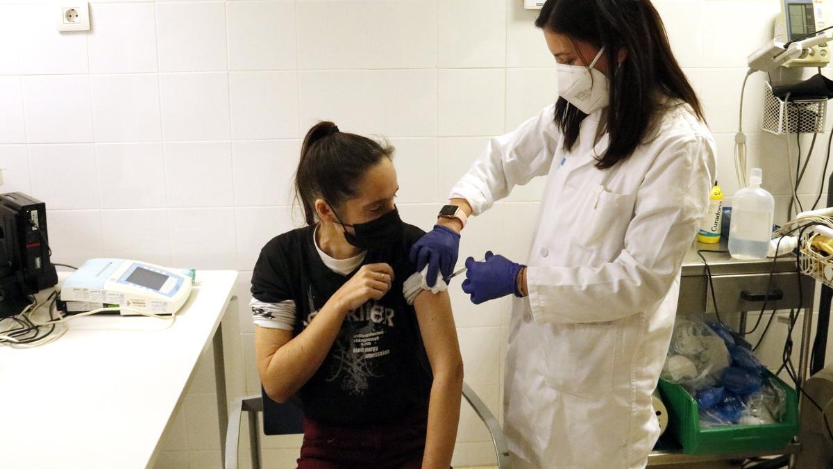 Una dona es vacuna contra la covid i la grip