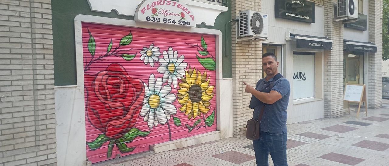 Jose del Castillo, presidente vecinal de Nueva Málaga, delante de uno de los comercios del barrio con la nueva decoración.