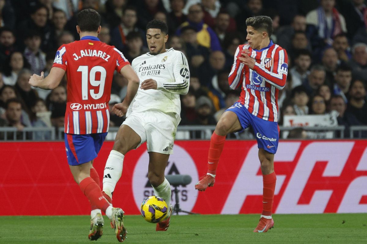MADRID, 08/02/2025.- El centrocampista inglés del Real Madrid Jude Bellingham (C) pelea un balón ante el delantero argentino del Atlético de Madrid Julián Álvarez (i) durante el encuentro correspondiente a la jornada 23 de Laliga EA Sports que disputan hoy sábado Real Madrid y Atlético de Madrid en el estadio Santiago Bernabéu, en Madrid. EFE / Juanjo Martín