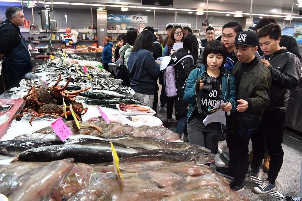 Una treintena de alumnos del Centro de Linguas de la Universidad coruñesa procedentes de China y Vietnam visitan el mercado de la plaza de Lugo para aprender argot gastrónomico gallego.