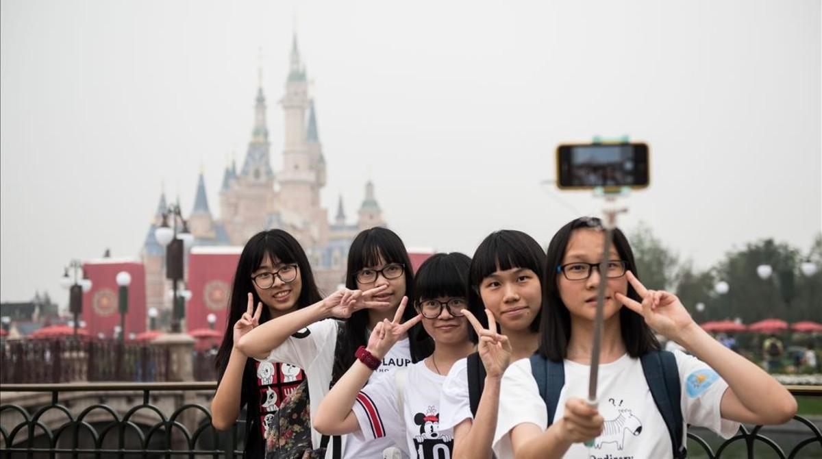 Unas visitantes al nuevo parque Disney en hacen un selfie durante la ceremonia de inauguración.