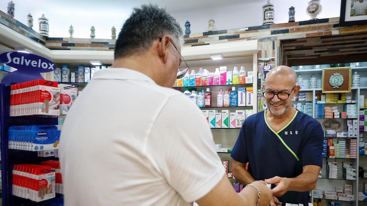 Un trabajador atiende a un cliente en una farmacia.