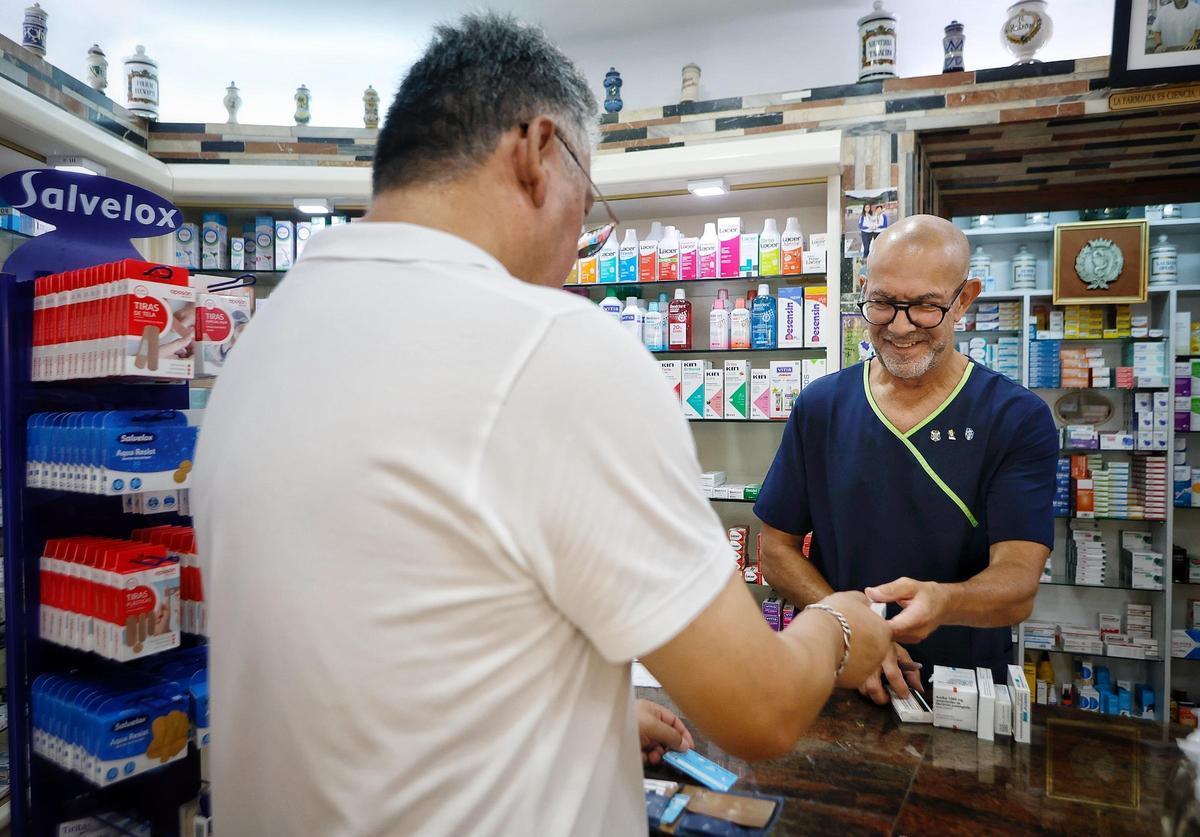 Un trabajador atiende a un cliente en una farmacia.