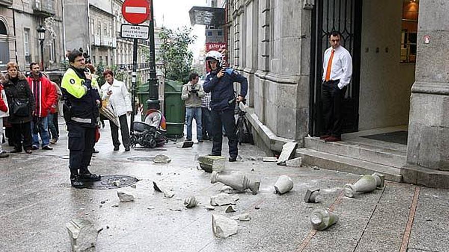 Parte de los escombros del balcón caído en calle Príncipe esta mañana. Al fondo, el carrito del bebé herido.