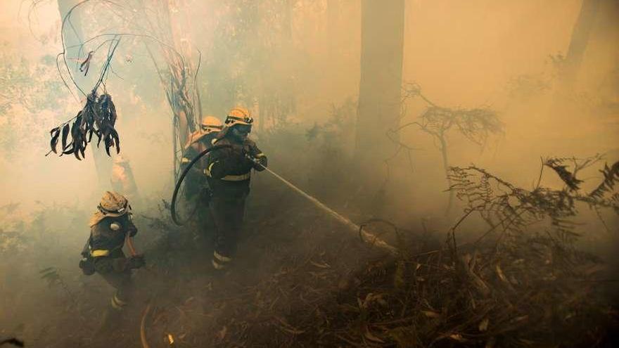 Bomberos apagando el fuego de Porto do Son. // Efe