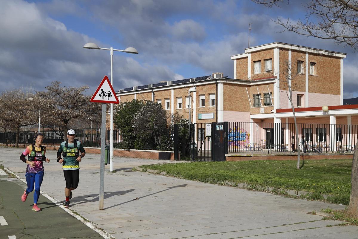 Dos deportistas pasan delante del colegio Alfonso Churruca, en la barriada de Las Palmeras.