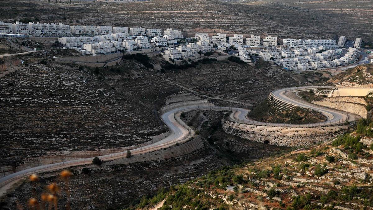 TOPSHOT - A serpentine road extends between the Jewish settlement of Givat Zeev (background) from Palestinian villages near the Israeli-occupied West Bank city of Ramallah  on June 10  2020  - Israel intends to annex West Bank settlements and the Jordan Valley  as proposed by US President Donald Trump  with initial steps slated to begin from July 1  (Photo by Ahmad GHARABLI   AFP)
