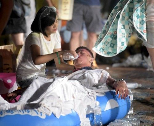 A person helps an injured victim from an accidental explosion during a music concert at the Formosa Water Park in New Taipei City