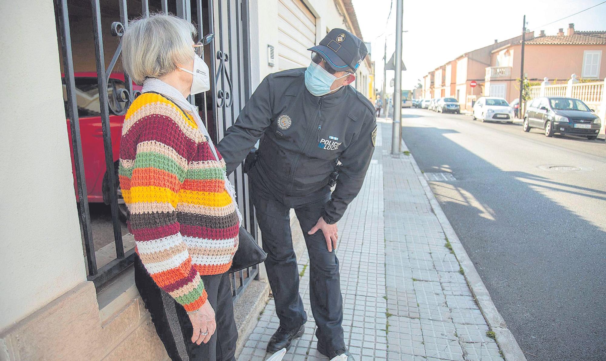 Gaspar Moll atiende auna vecina que se ha  caído en la calle.  | GUILLEM BOSCH