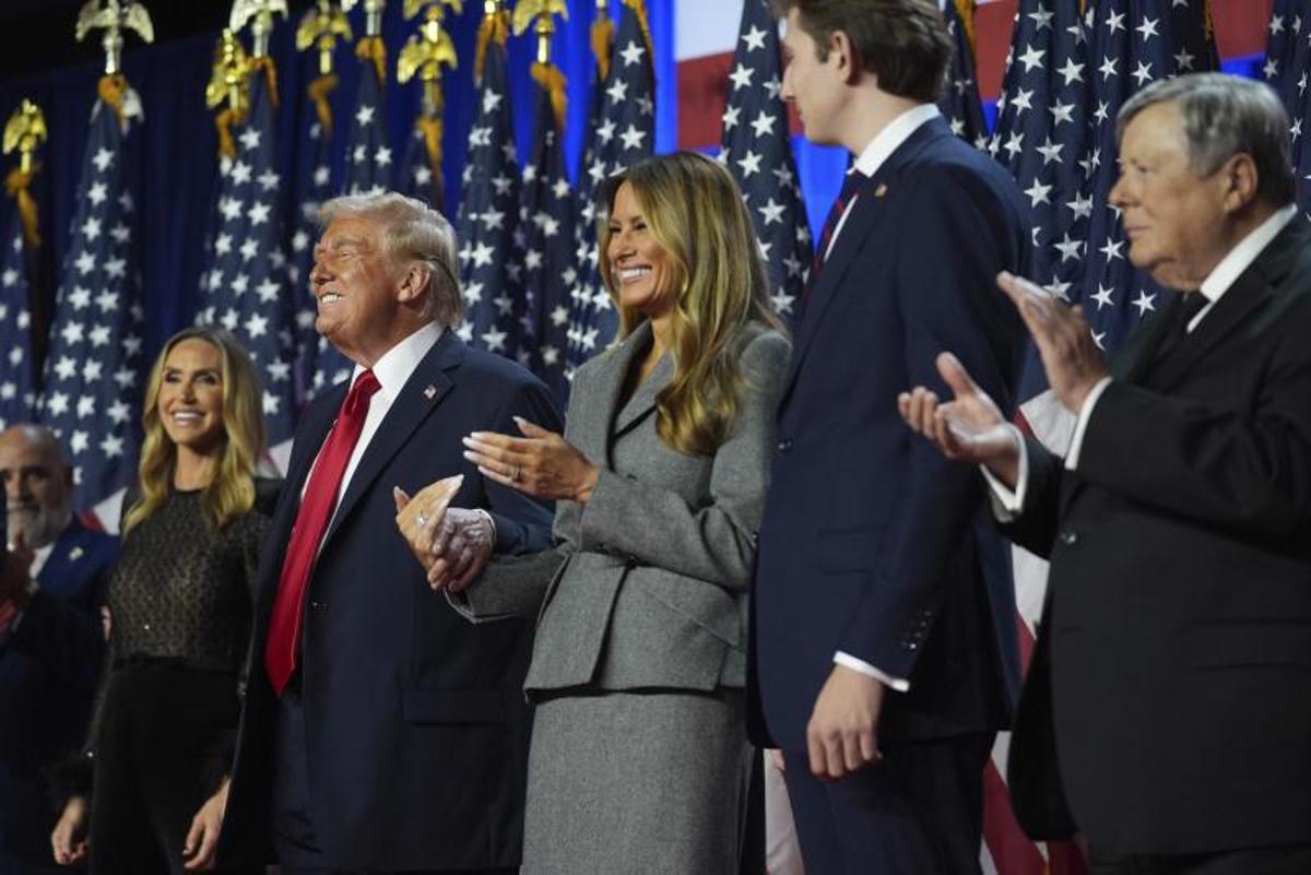 El candidato presidencial republicano, el ex presidente Donald Trump, sonríe mientras Lara Trump, la ex primera dama Melania Trump, Barron Trump y Viktor Knavs observan, en una fiesta de observación de la noche electoral en el Centro de Convenciones de Palm Beach en West Palm Beach, Florida.