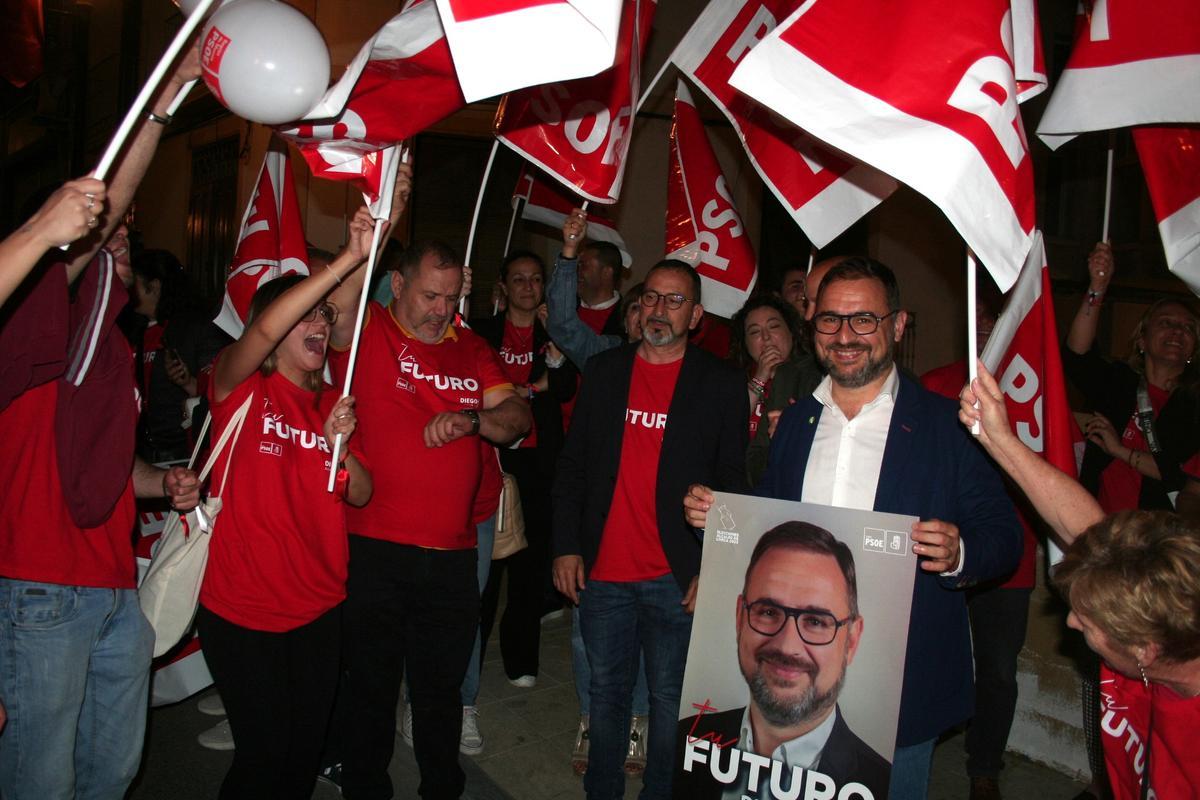 El alcalde y candidato a la Alcaldía del PSOE, Diego José Mateos, con uno de los carteles instantes antes de colocarlo.
