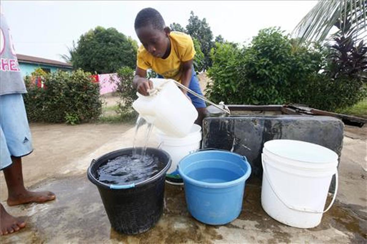 Un niño saca agua de un pozo situado en Johnsonville Commuity, a las afueras de Monrovia, Liberia  