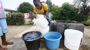 Un niño saca agua de un pozo situado en Johnsonville Commuity, a las afueras de Monrovia, Liberia  
