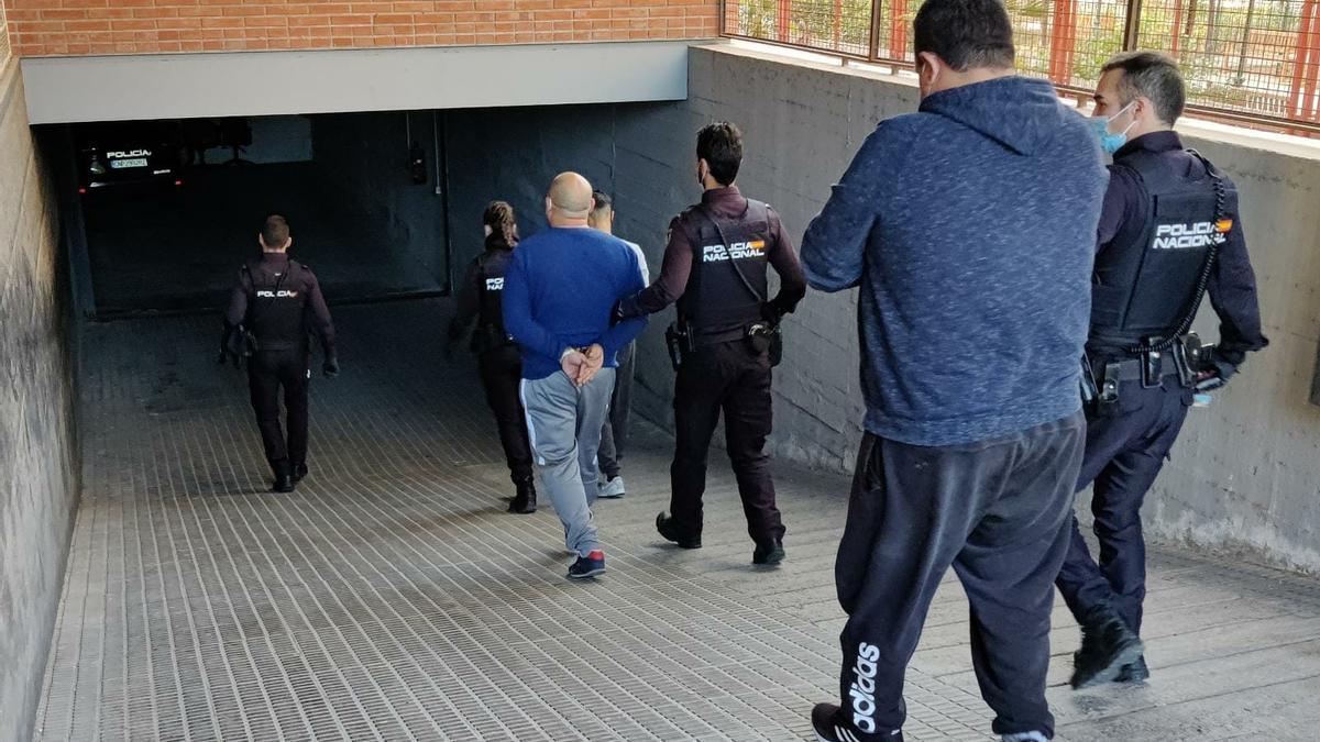 Los agentes, acompañando a los detenidos.