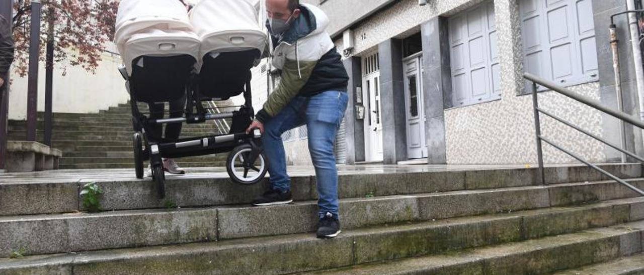 Una pareja baja un carrito de bebé por las escaleras de la calle Villar Chao.  | // LOC