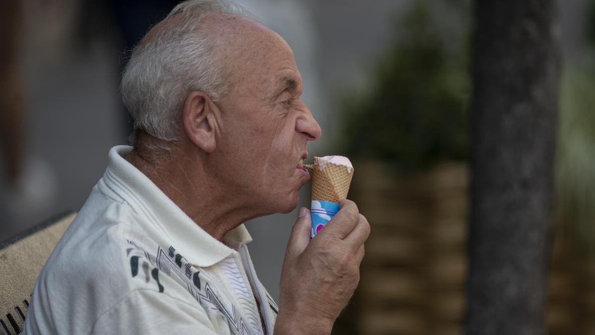 Un mayor come un helado a la sombra, en Ourense.
