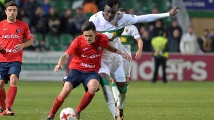 Ivan Guzmán, de l&#039;Olot, lluita una pilota amb Sory, futbolista de l&#039;Elx.