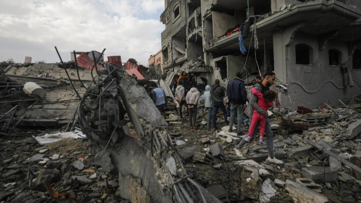 Palestinos buscan cadáveres y supervivientes entre los escombros de la casa destruida de la familia Manasra tras un ataque aéreo israelí en el sur de la Franja de Gaza, el 25 de diciembre de 2023.