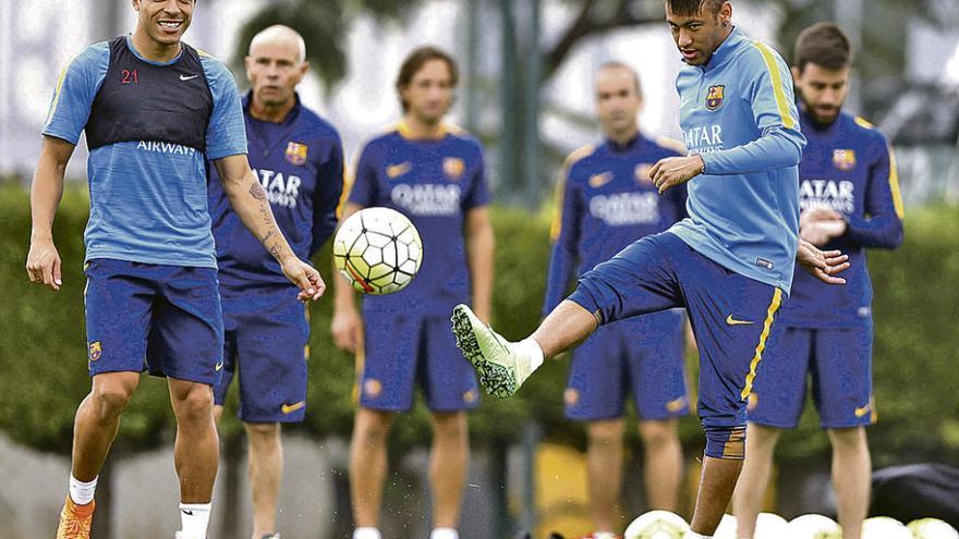 Neymar golpea el balón en presencia de Adriano durante el entrenamiento de ayer del Barcelona.