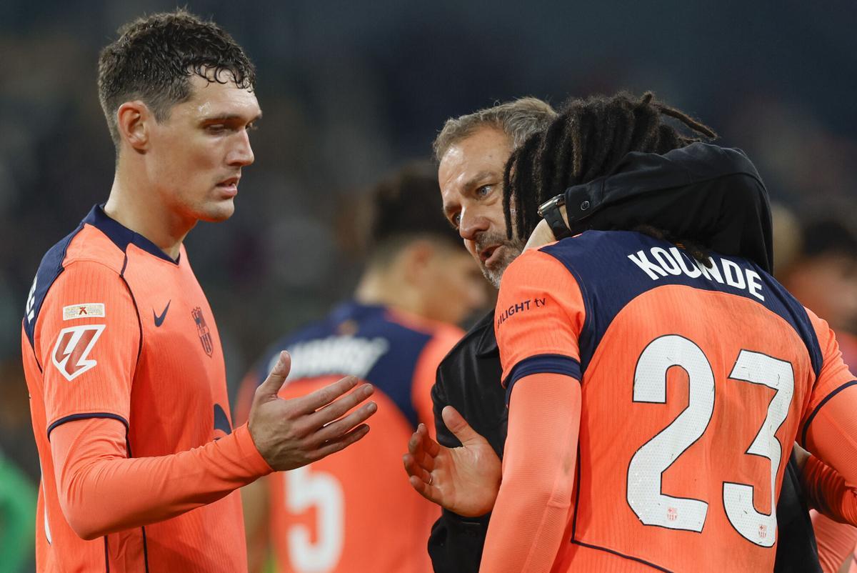SEVILLA, 06/12/2025.- El entrenador del Barcelona, Hansi Flick, y los jugadores Jules Koundé (d) y Andreas Christensen (i), al término del partido de LaLiga EA Sports que Real Betis y FC Barcelona disputan este sábado en el estadio de La Cartuja, en Sevilla. EFE/Julio Muñoz