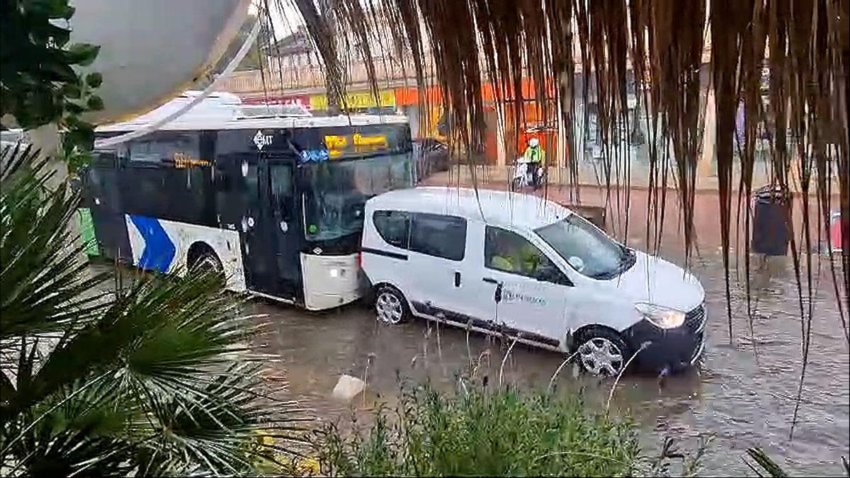 Un conductor de la EMT empuja con el autobús a un coche averiado durante el aguacero en s'Arenal