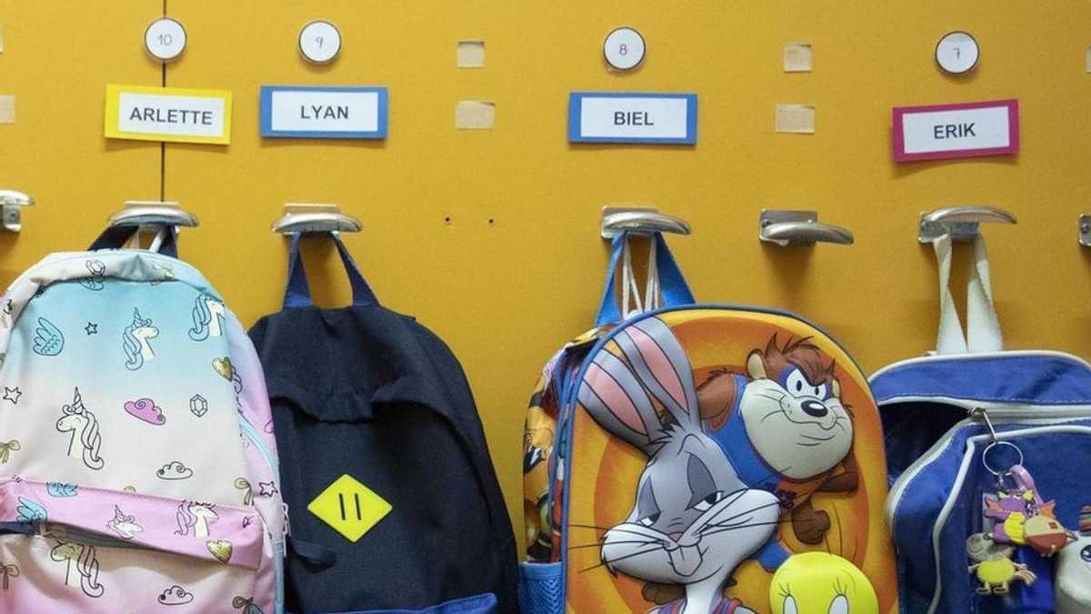 Motxilles penjades al penjador en una aula.