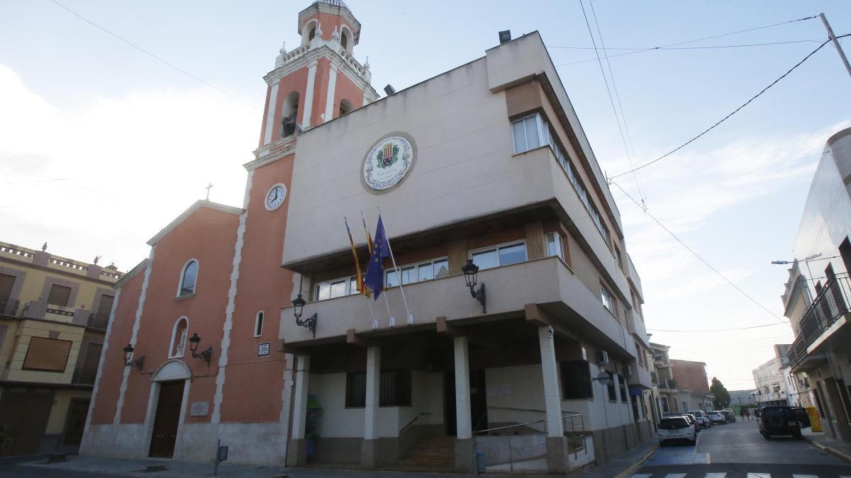 Un vecino de Cárcer pasa con su bicicleta ante la casa consistorial de Càrcer.