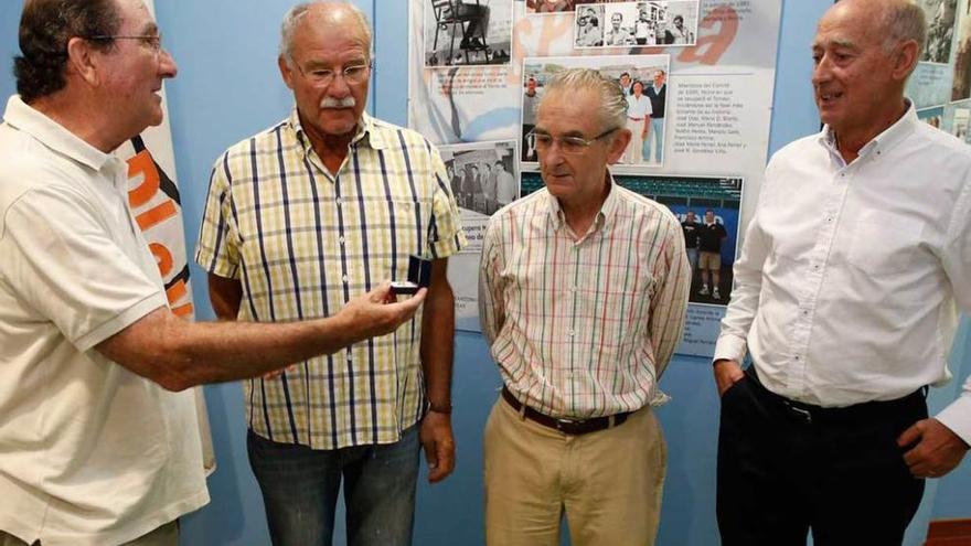 José Manuel Fernández muestra una insignia de plata en presencia de Enrique García, José Ramón Ovies y José Ramón García, ayer, en la exposición sobre el tenis-playa en el Museo Marítimo.