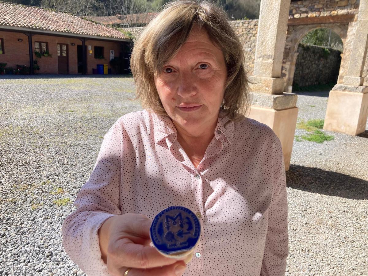 Gloria Fernández, gerente del albergue municipal de Cornellana, muestra el sello especial del milenario