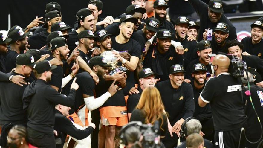 Robert Sarver, agachado, celebra con los Suns su triunfo en Los Ángeles.