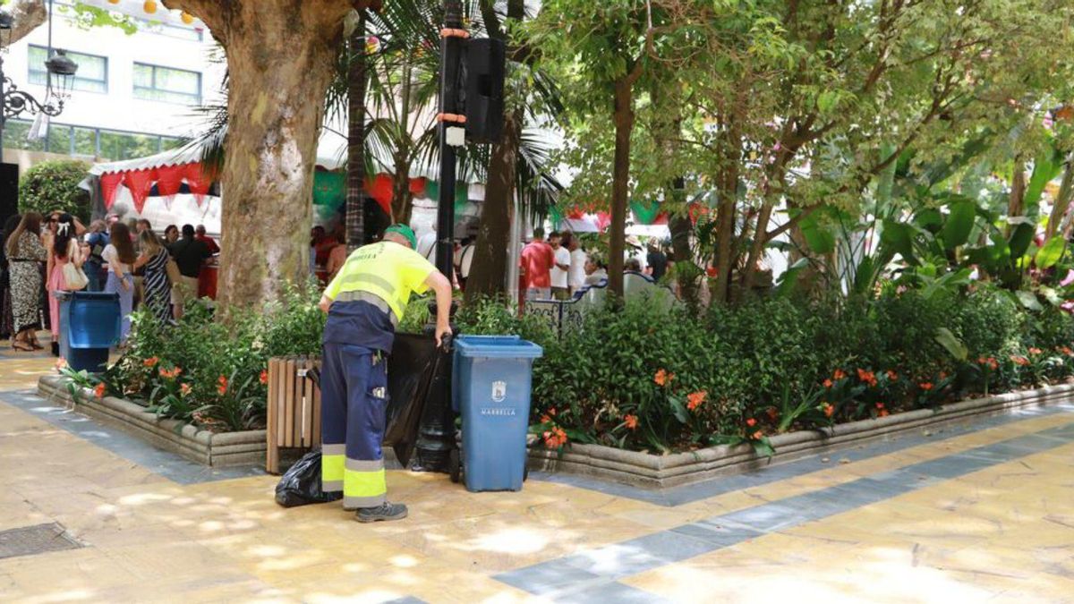 Un operario de la limpieza vacía una papelera en el centro urbano.