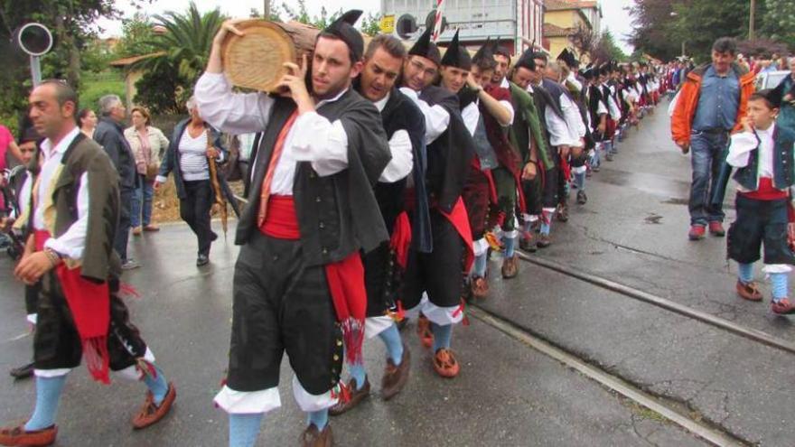 Los mozos, con la hoguera del Cristo a hombros, ayer por la tarde, en Nueva de Llanes.