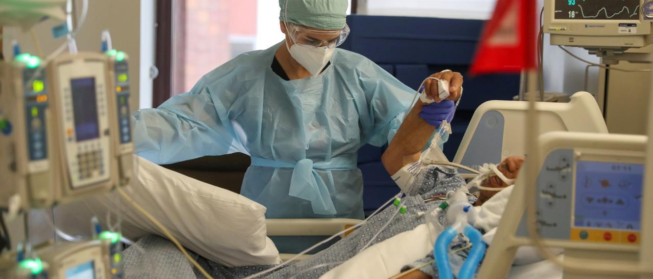 Una sanitaria atiende a un paciente covid.