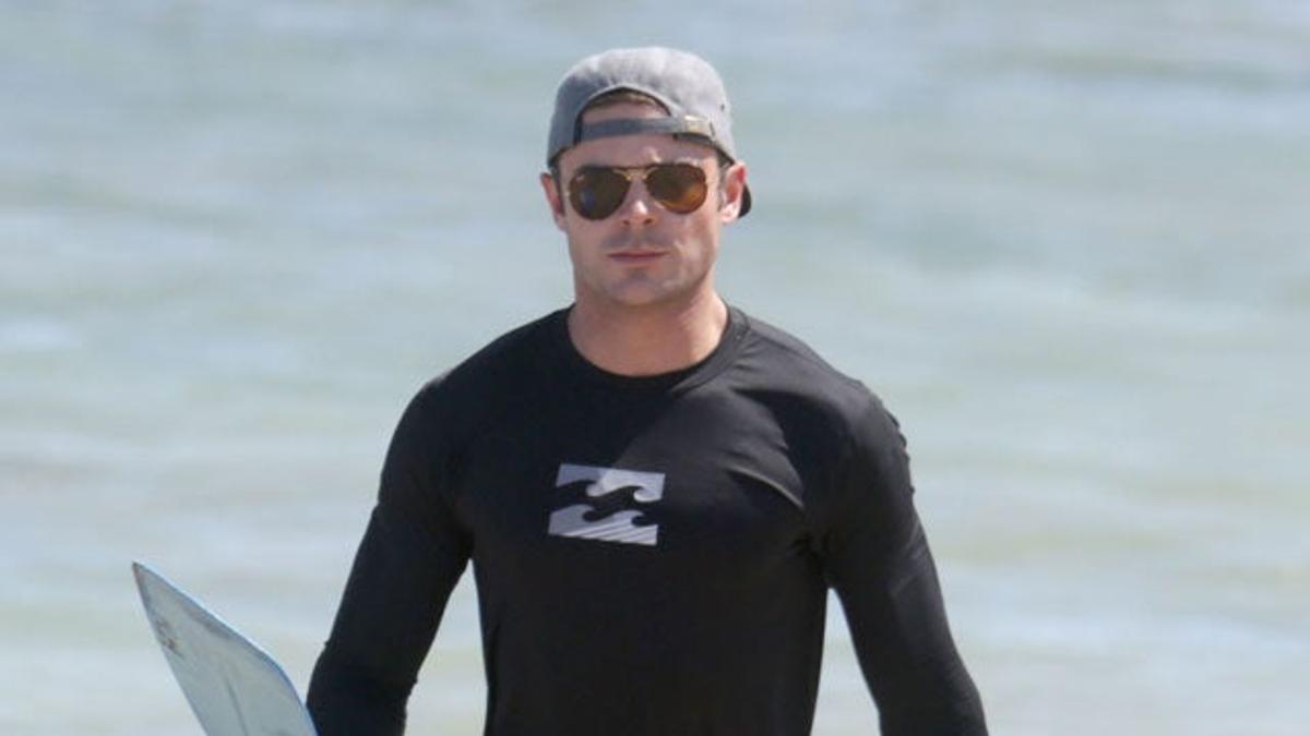 Zac Efron con la pala y la tabla preparado para hacer paddle surf