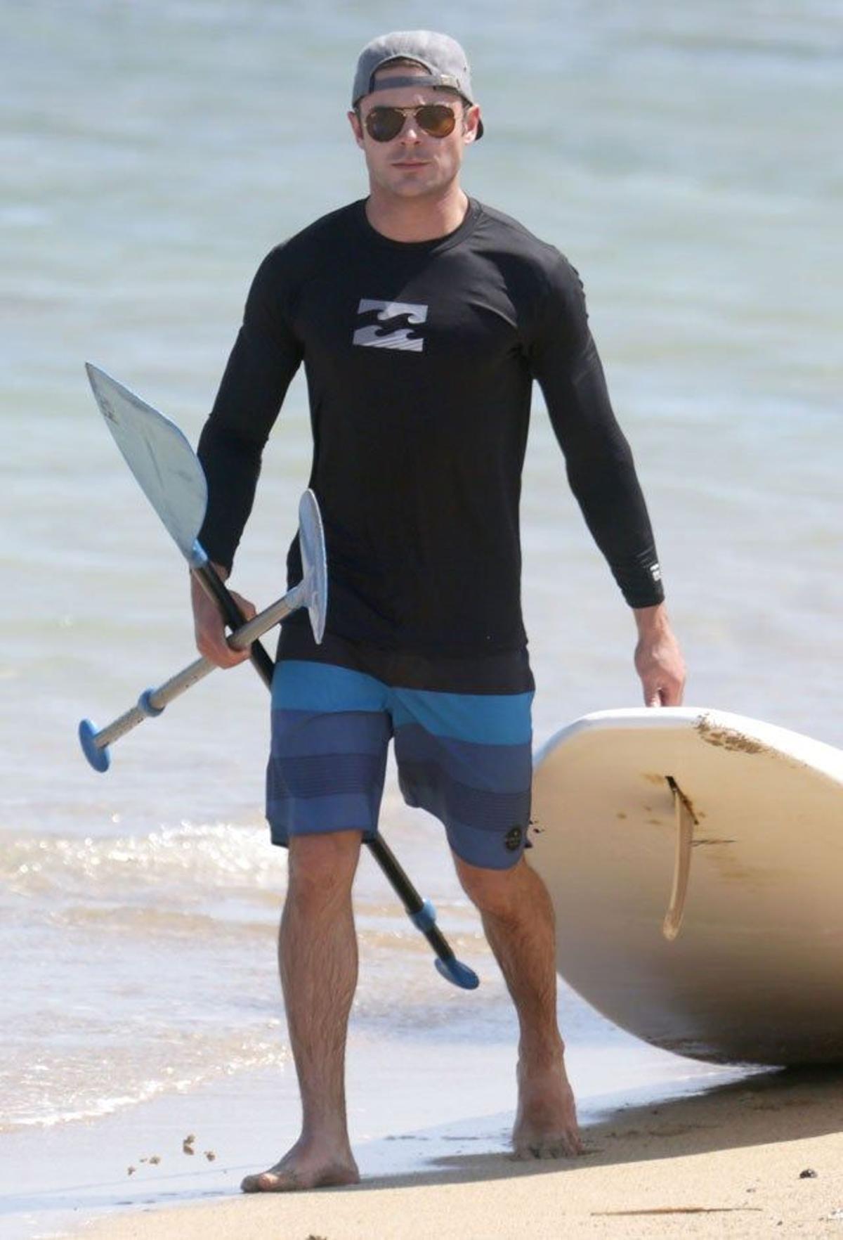 Zac Efron con la pala y la tabla preparado para hacer paddle surf