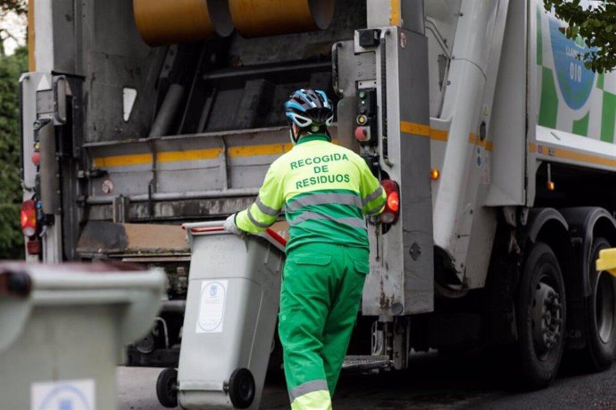 Un trabajador recogiendo un cubo de basura en Madrid.