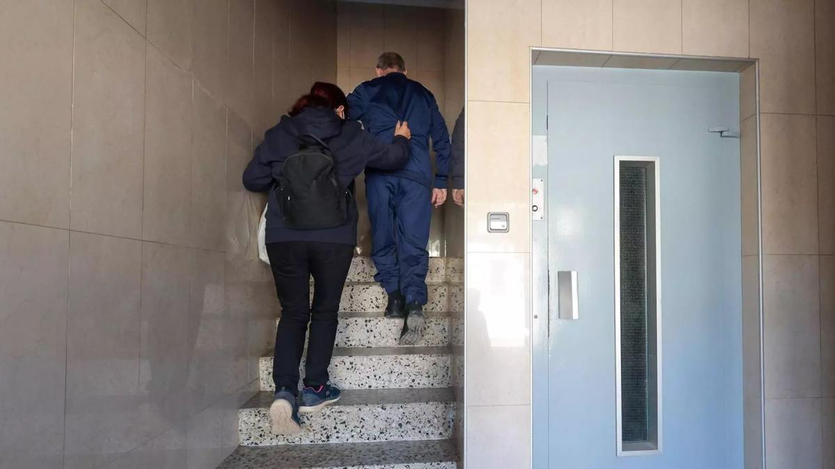 Jose, vecino de Aldaia, sube las escaleras con la ayuda de su mujer Josefa ante la ausencia de ascensor.