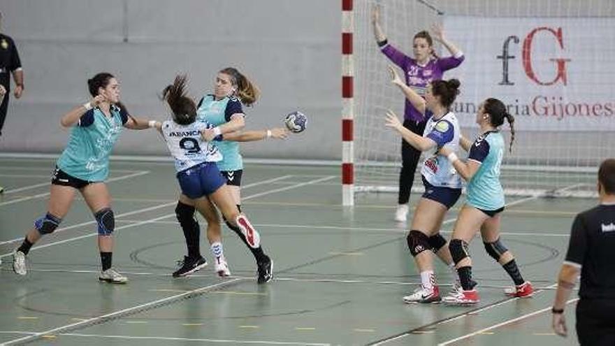 Las jugadoras del Balonmano Gijón defienden el ataque de Da Silva.